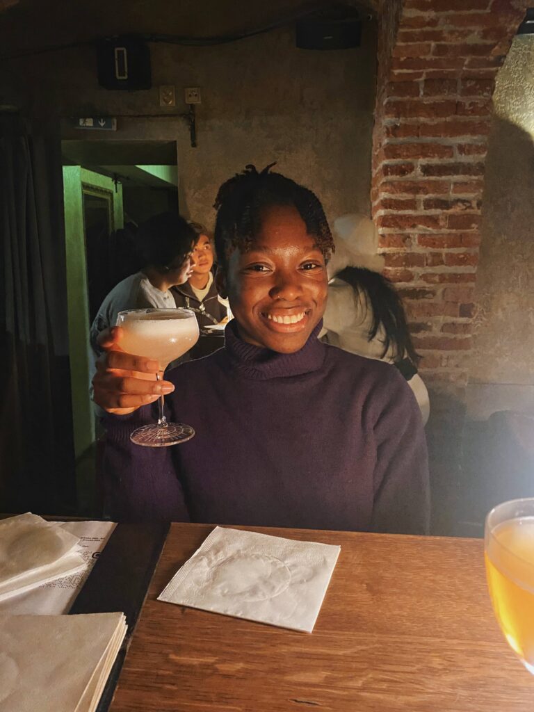 Abigail holding her cocktail at the AnonymouS Shrink's Office speakeasy in Prague