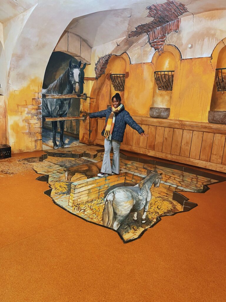 Abigail walking on a wall illusion at the Museum of Senses in New Town Prague