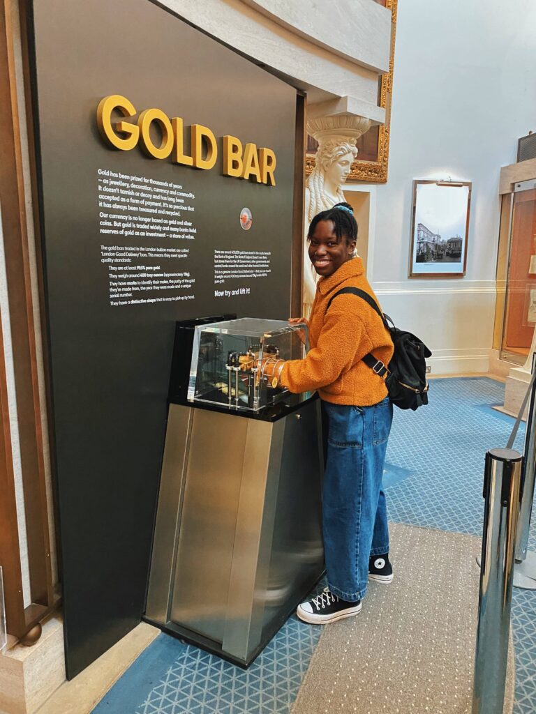 Abigail holds a gold bar in the Bank of England musem
