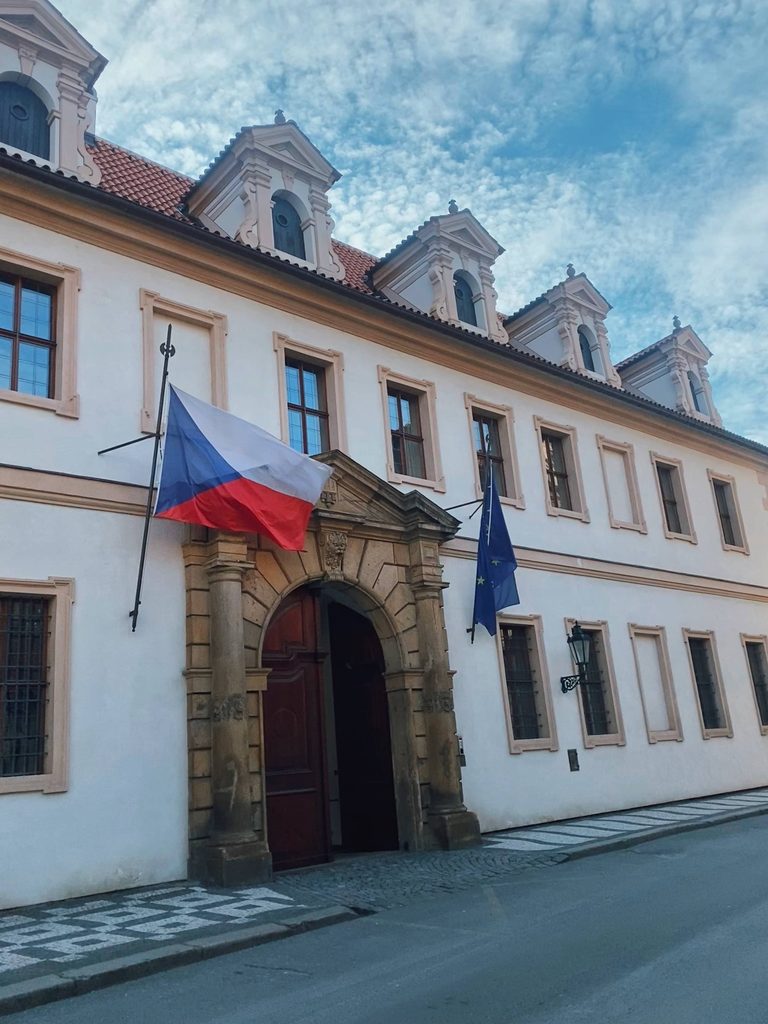 A building with a Czechia flag and an EU flag waving at the front
