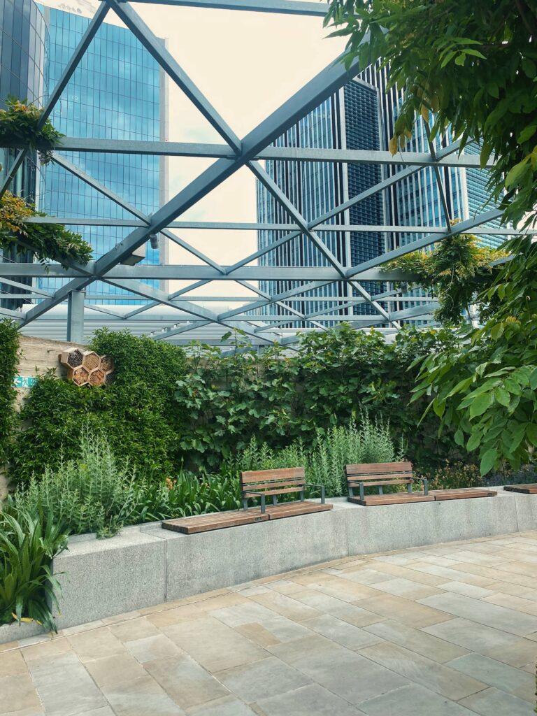 An area with plants and benches in front of them at Garden at 120