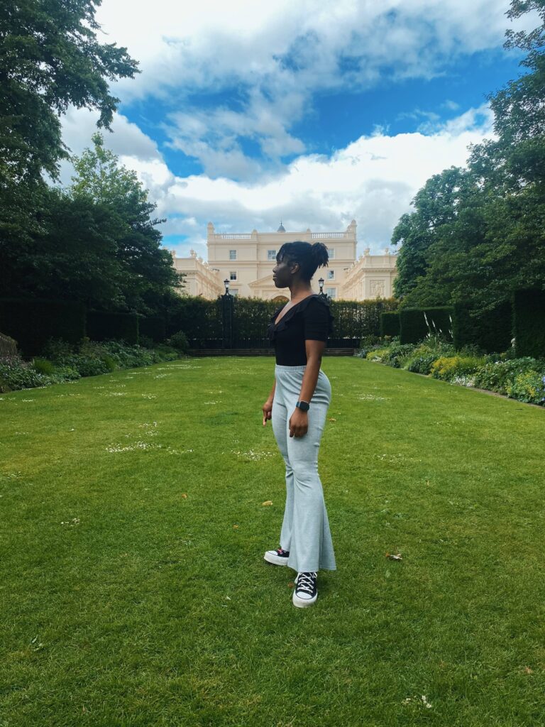 Abigail standing on the lawn in St John's Lodge Garden in Regent's Park, London, with the villa in the background