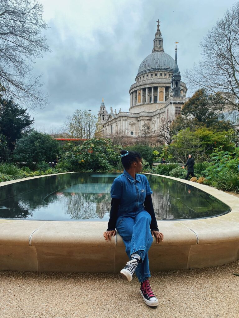 Abigail sitting by a reflection pool looking at St Paul's Cathedral